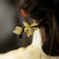 Light green orchid hair ornament styled in dark hair