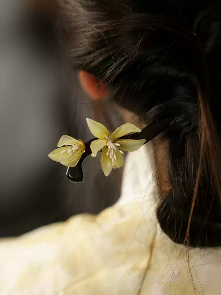 Light green orchid hair ornament styled in dark hair