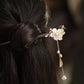 Orchid hair stick with a delicate hanging tassel styled in a bun