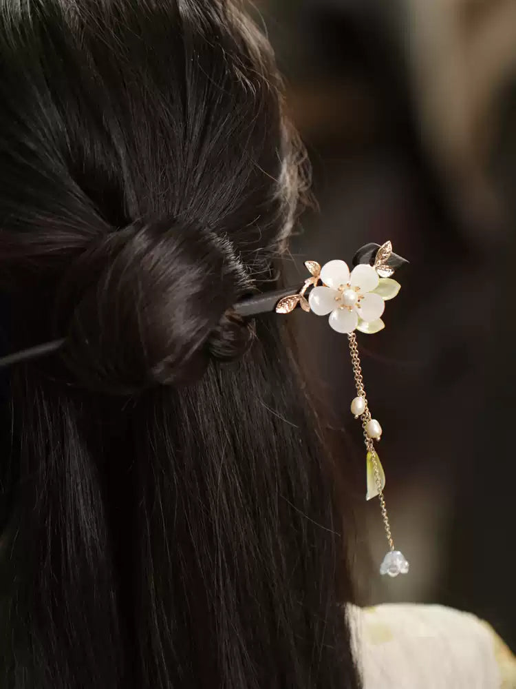 Orchid hair stick with a delicate hanging tassel styled in a bun