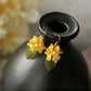 Close product view of the short golden osmanthus flower earrings with white accents