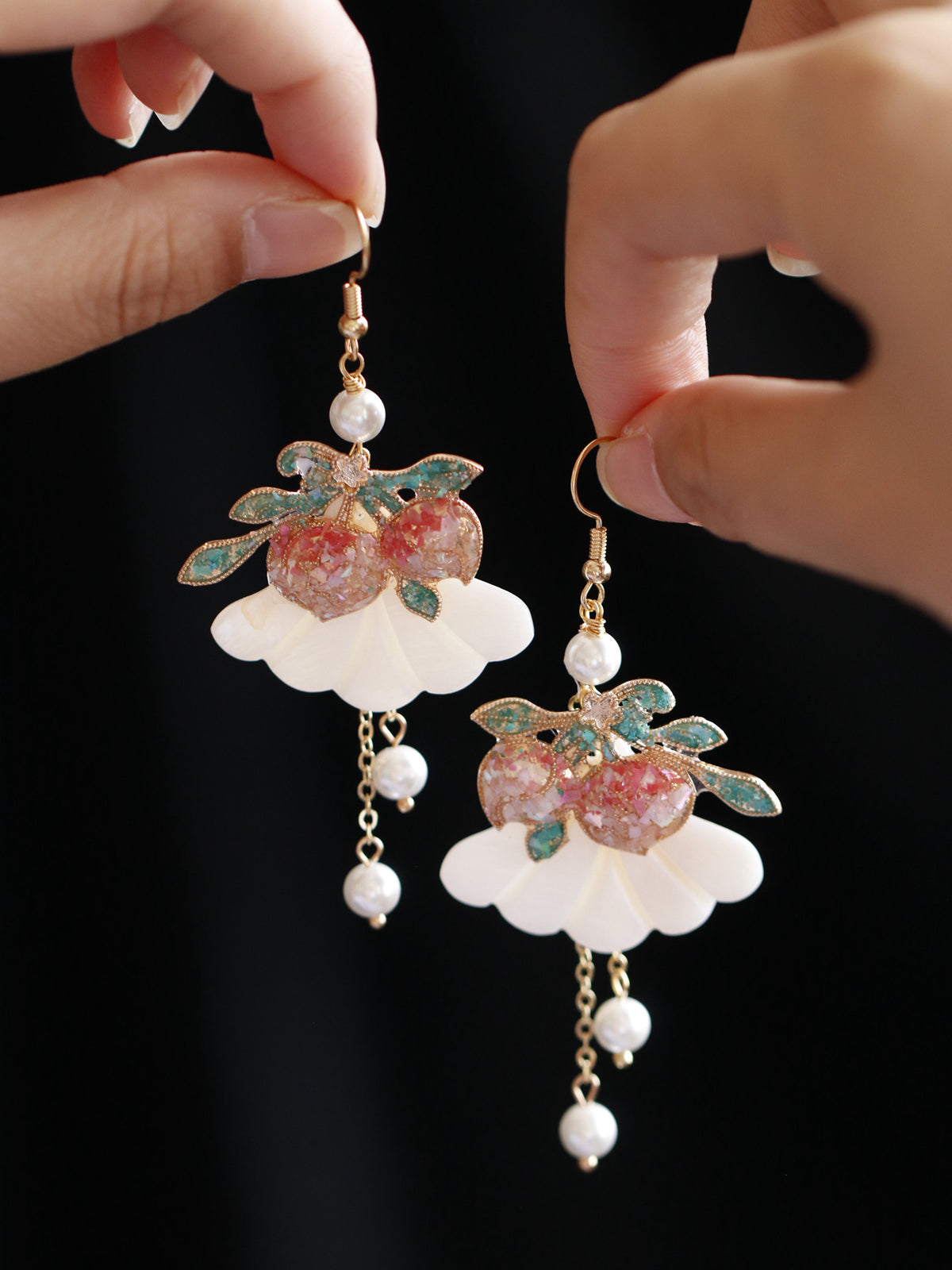 Close view of peach-shaped drop earrings