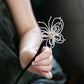 Close-up of the pearl-beaded butterfly hairpin and wooden stick