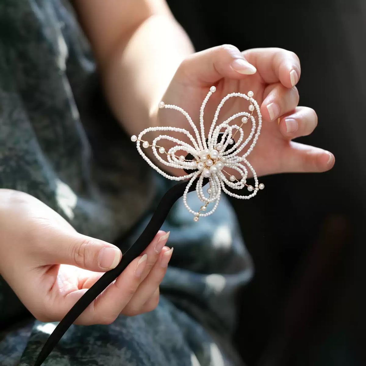 Side view of an openwork pearl butterfly hairpin