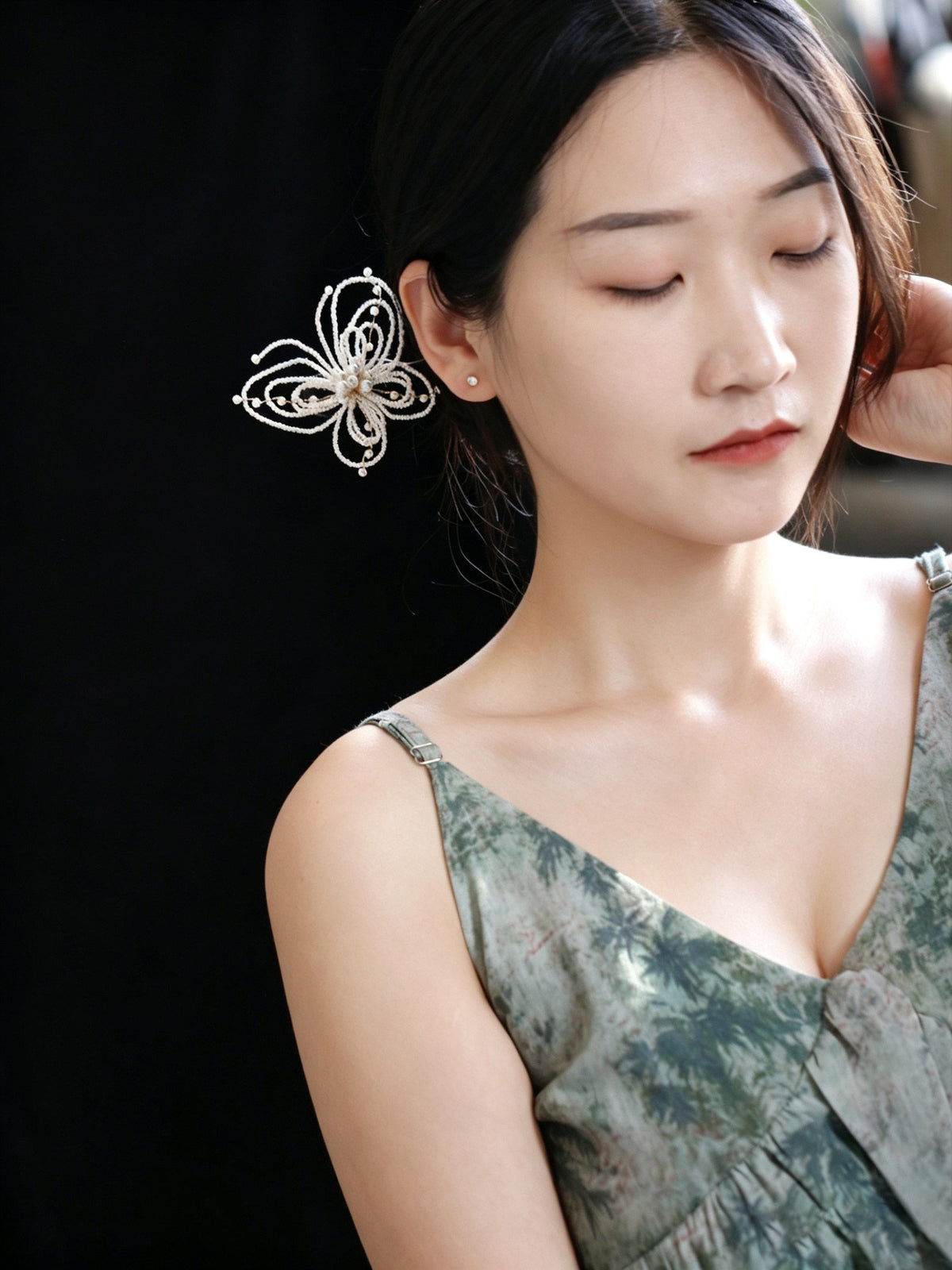 Model wearing a pearl-beaded butterfly hairpin in an updo