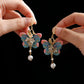 Close-up view of the pink and blue butterfly earring pair