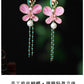 Detailed view of pink flower, pearl-look accent, and turquoise-tone bead chains