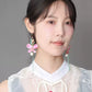 Front view of model wearing the long pink butterfly earrings