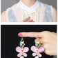 Pink butterfly earrings shown worn and in a close-up view
