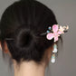 Back view of a bun styled with the pink butterfly hairpin