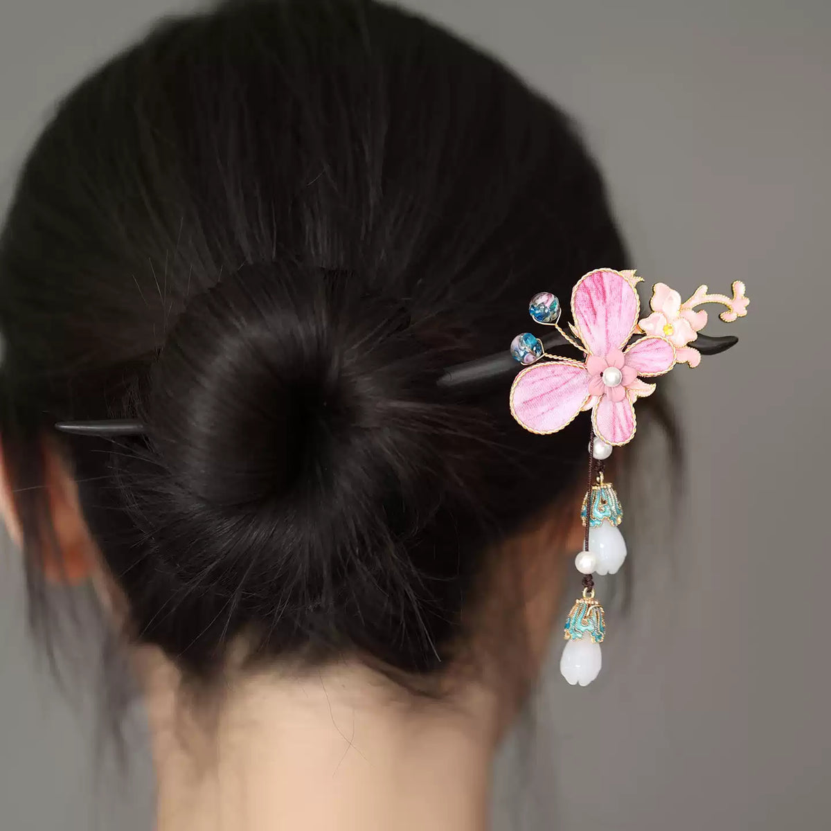 Back view of a bun styled with the pink butterfly hairpin