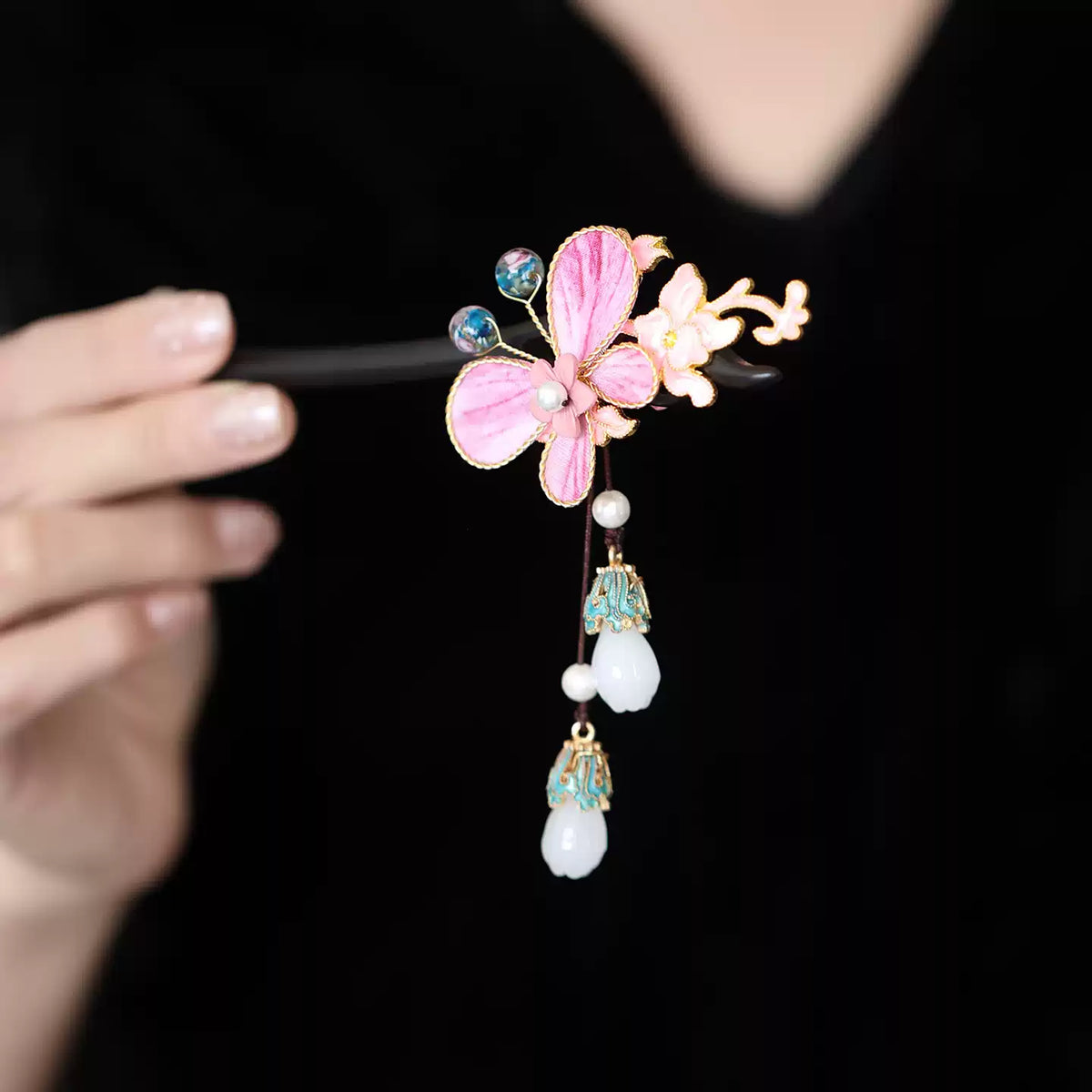 Hand-held close-up of the pink butterfly floral hairpin