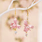 Close view of pink iris flower earrings and faceted drop accents