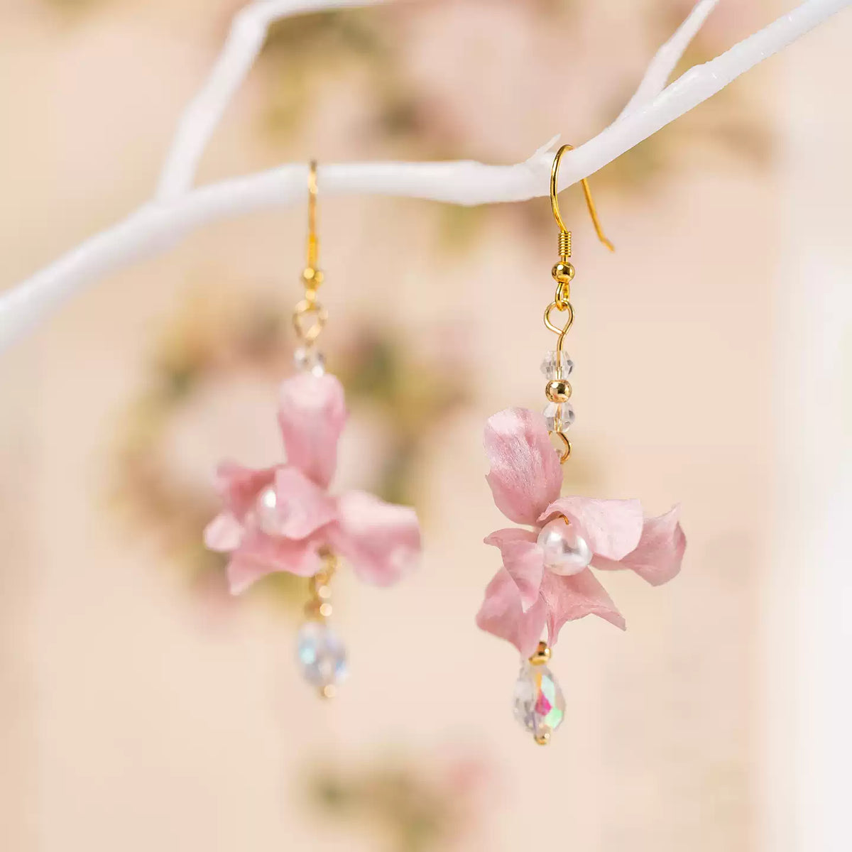 Close view of pink iris flower earrings and faceted drop accents
