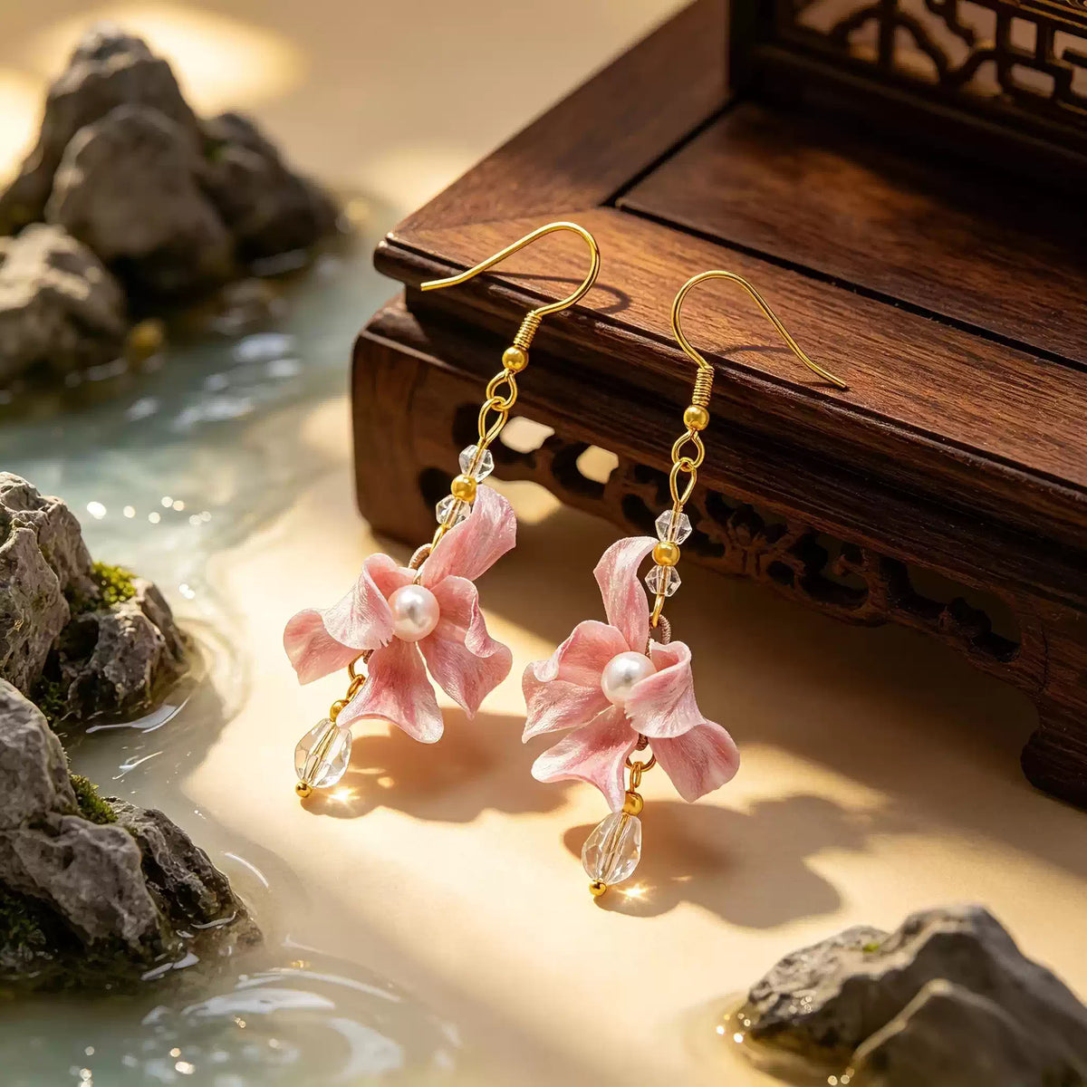 Pink iris flower earrings displayed against a traditional-style wood setting