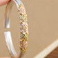 Close-up of pink peony enamel and raised silver cuff detailing