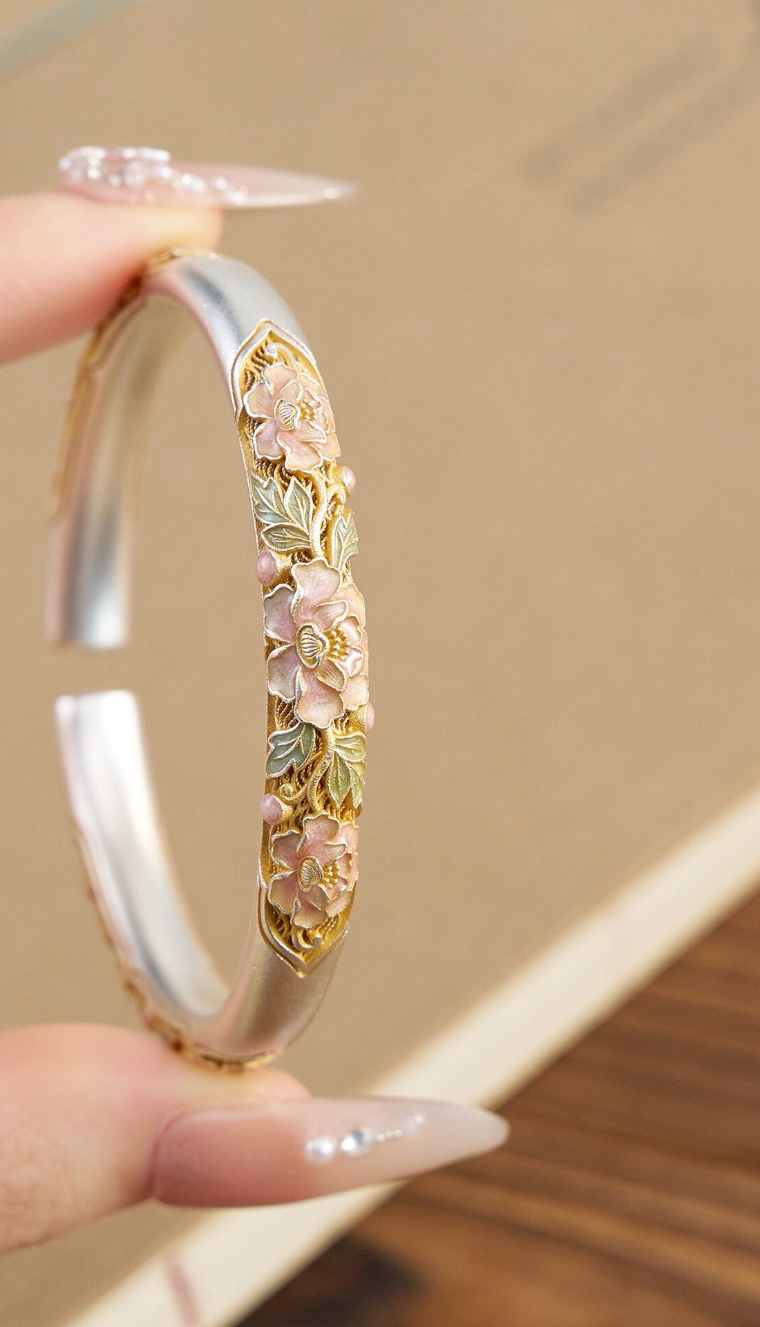 Close-up of pink peony enamel and raised silver cuff detailing