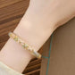 Pink peony enamel cuff bracelet worn on wrist, angled view