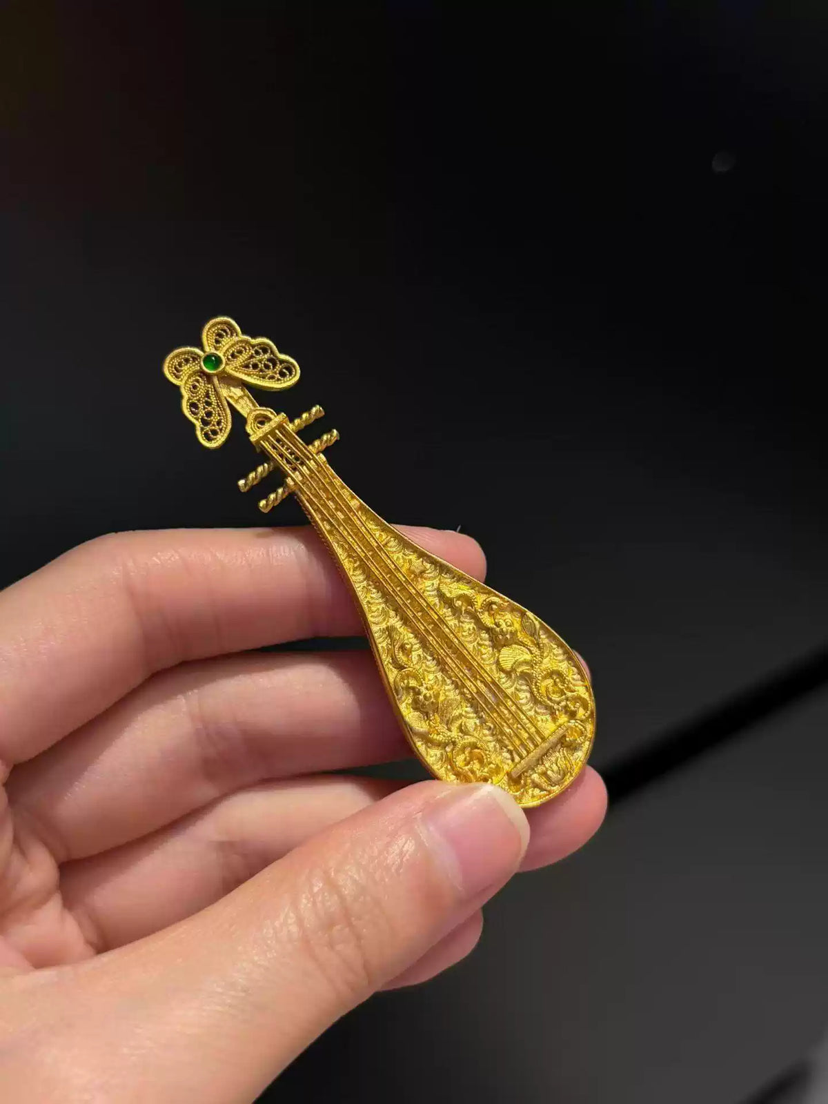 Gold-tone copper pipa brooch with a green accent and raised dragon motif