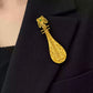 Pipa-shaped copper brooch pinned to a jacket