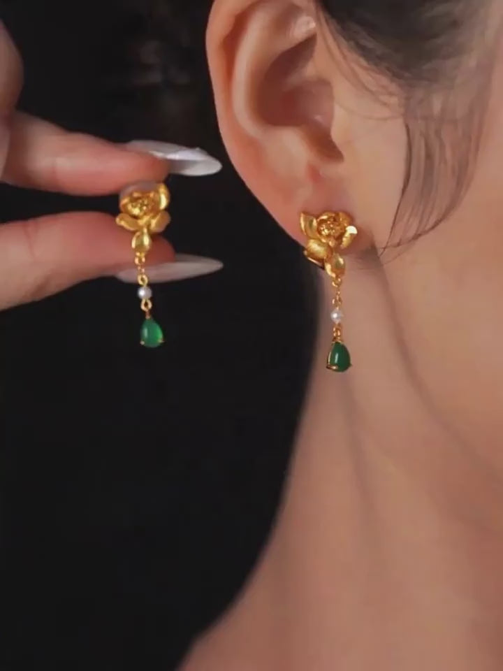 Product video showing the gold-tone lotus-style drop earrings with green accents