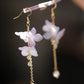 Close-up of a purple hydrangea earring and chain detail