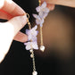 Purple flower earring detail with long chain and pale drop