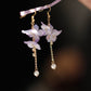 Pair of long purple flower earrings worn, side view