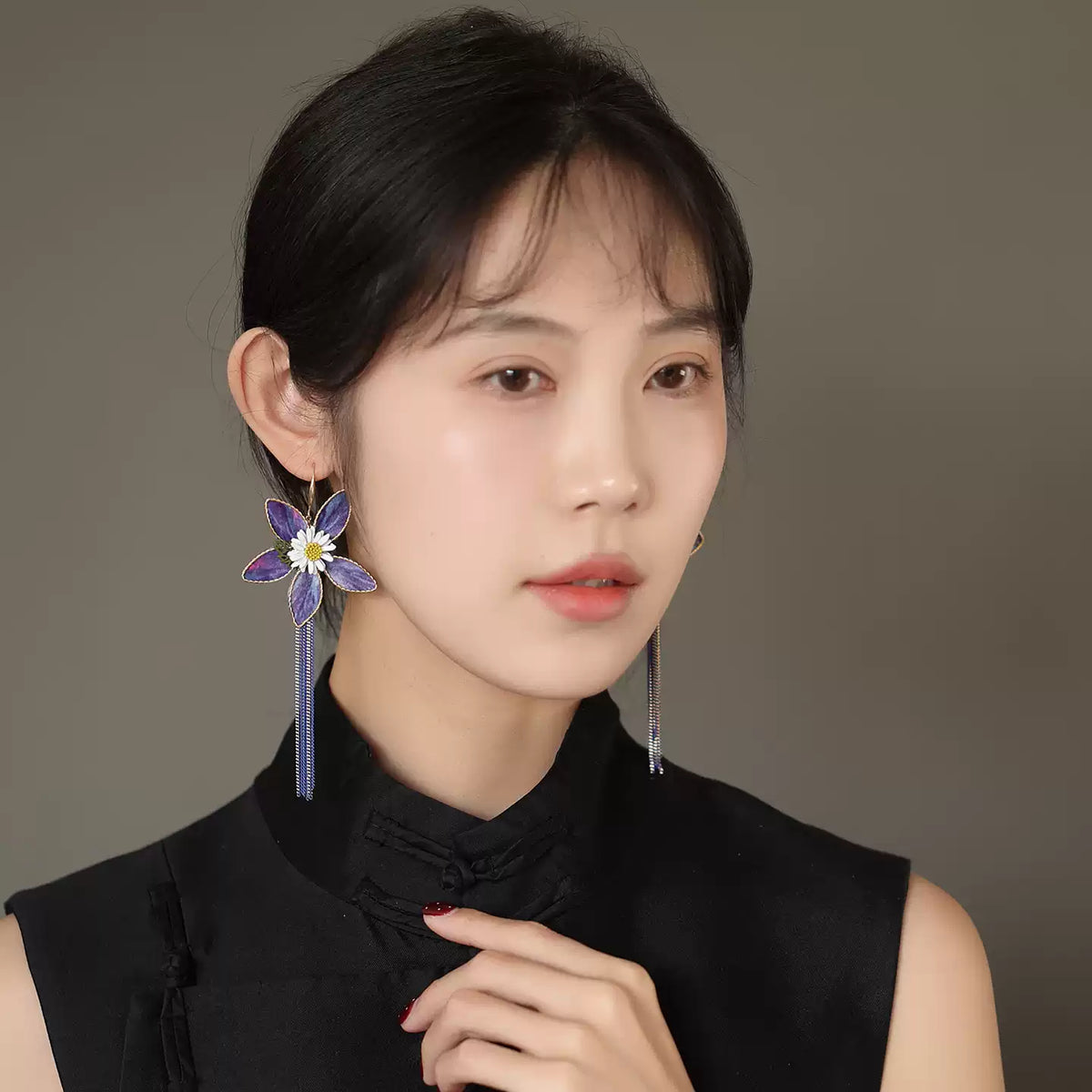 Front view of purple floral drop earring worn