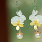 Pair of rabbit and osmanthus-inspired earrings in a styled product setting