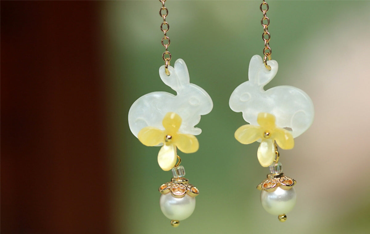Pair of rabbit and osmanthus-inspired earrings in a styled product setting