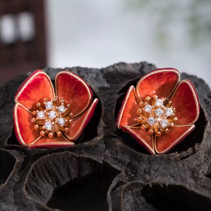 Red plum blossom stud earrings with gold-tone edging and center accents