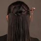 Red tassel hairpin styled in a bun, rear view
