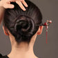 Red hanging tassel hairpin worn in an updo