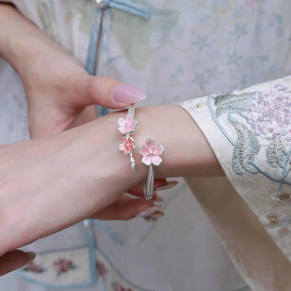 Pink enamel cherry blossom open cuff bracelet worn on the wrist