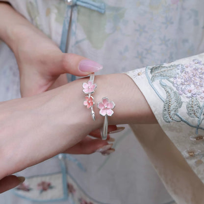 Pink enamel cherry blossom open cuff bracelet worn on the wrist