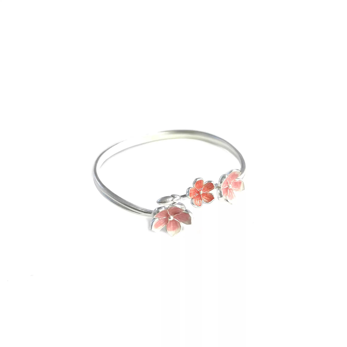 Full view of the open cuff bracelet with pink and red blossom details on a white background