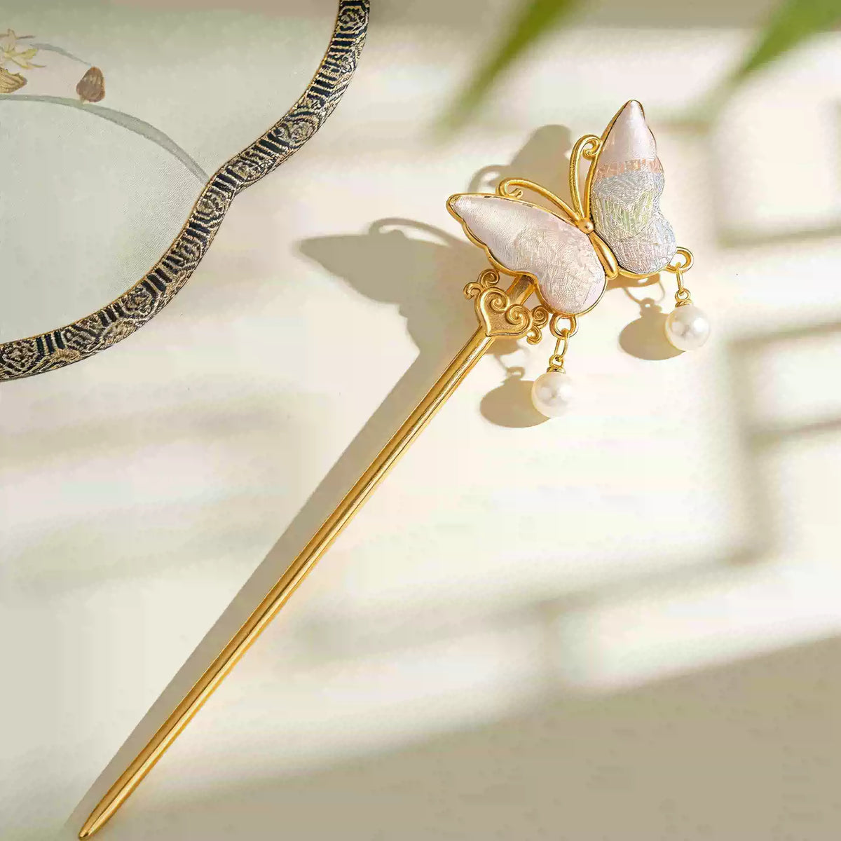 Close-up of the double-sided butterfly hair ornament in pale blue and pink textile