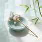 Song brocade butterfly hairpin styled beside a celadon dish