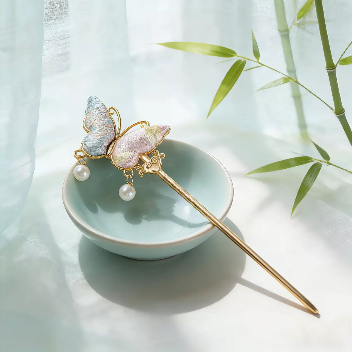 Song brocade butterfly hairpin styled beside a celadon dish