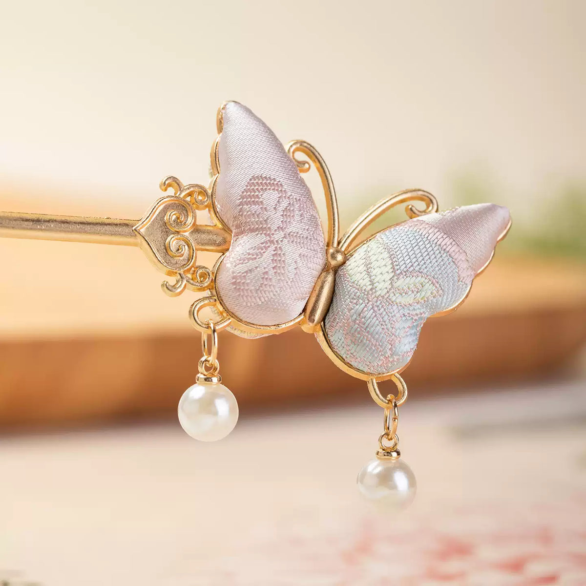 Detailed view of the brocade butterfly wings and pearl-style drops