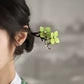 Side view of the floral hair stick secured in a bun