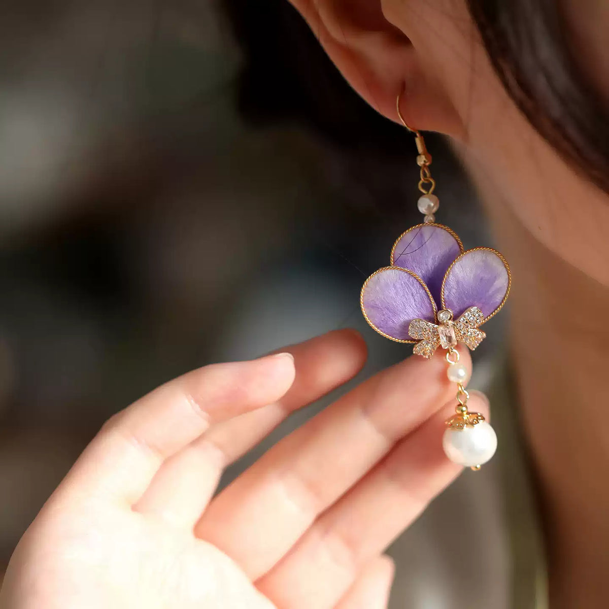 Violet velvet flower earring shown worn on the ear