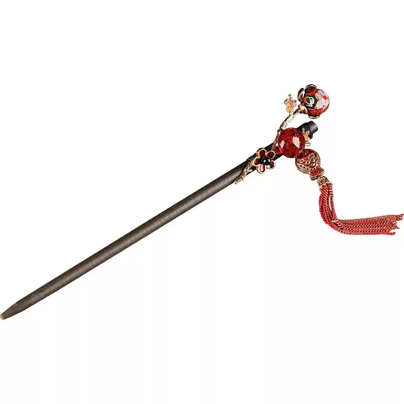 Wooden hair stick with red fish charm and long tassel on white background